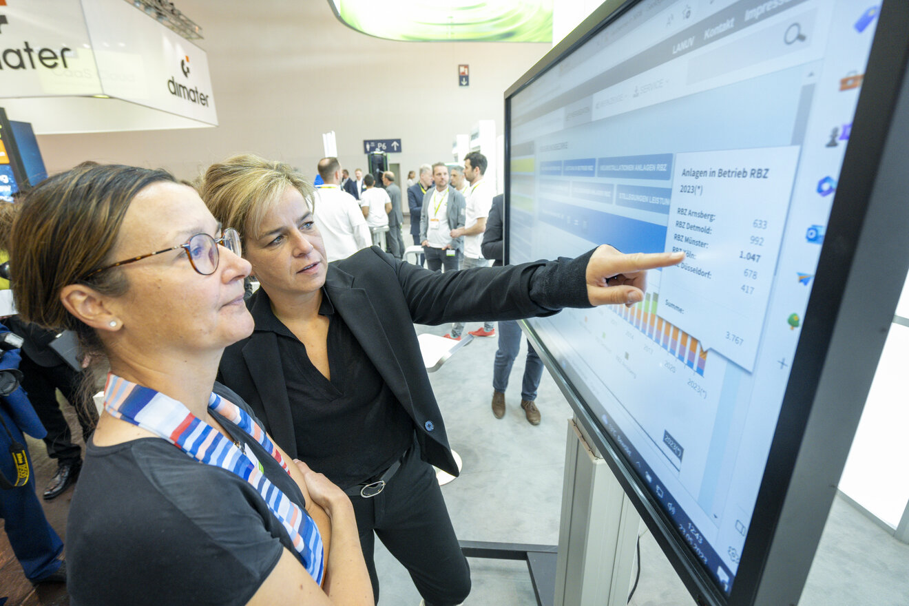 Ministerin Neubaur nutzt den Bildschirm vom Klimastand bei der E-World 2023. Auf dem Bildschirm ist das Solarkataster NRW zu sehen. Foto: Kai-Uwe Knoth, MWIKE